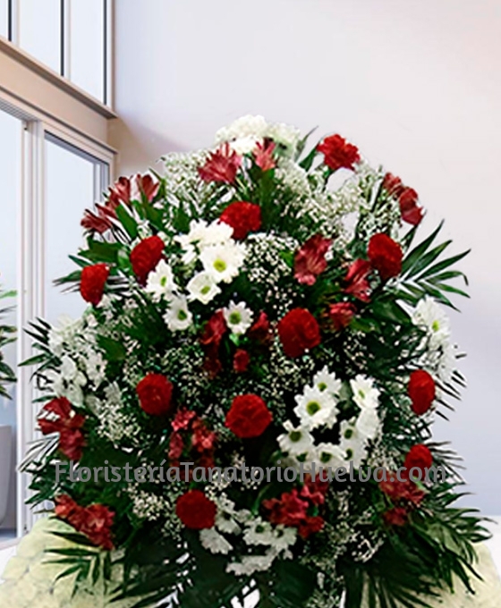 Corona floral funeraria blanca con un cabezal de flores para difuntos variada